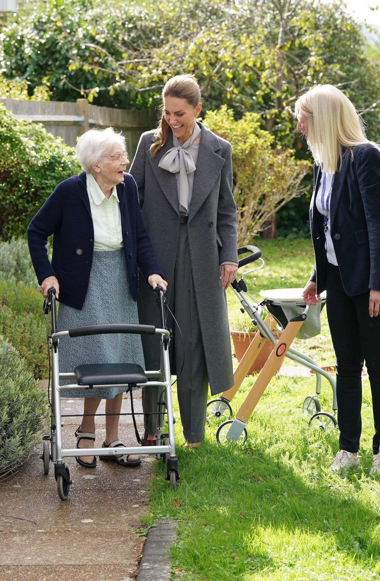 Princess Kate smiling at a woman walking with a walker in front of her house