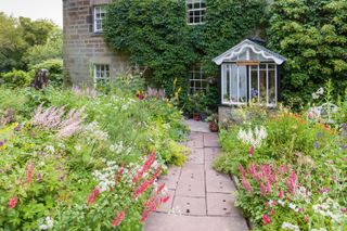 cottage garden with densely planted flowerbeds
