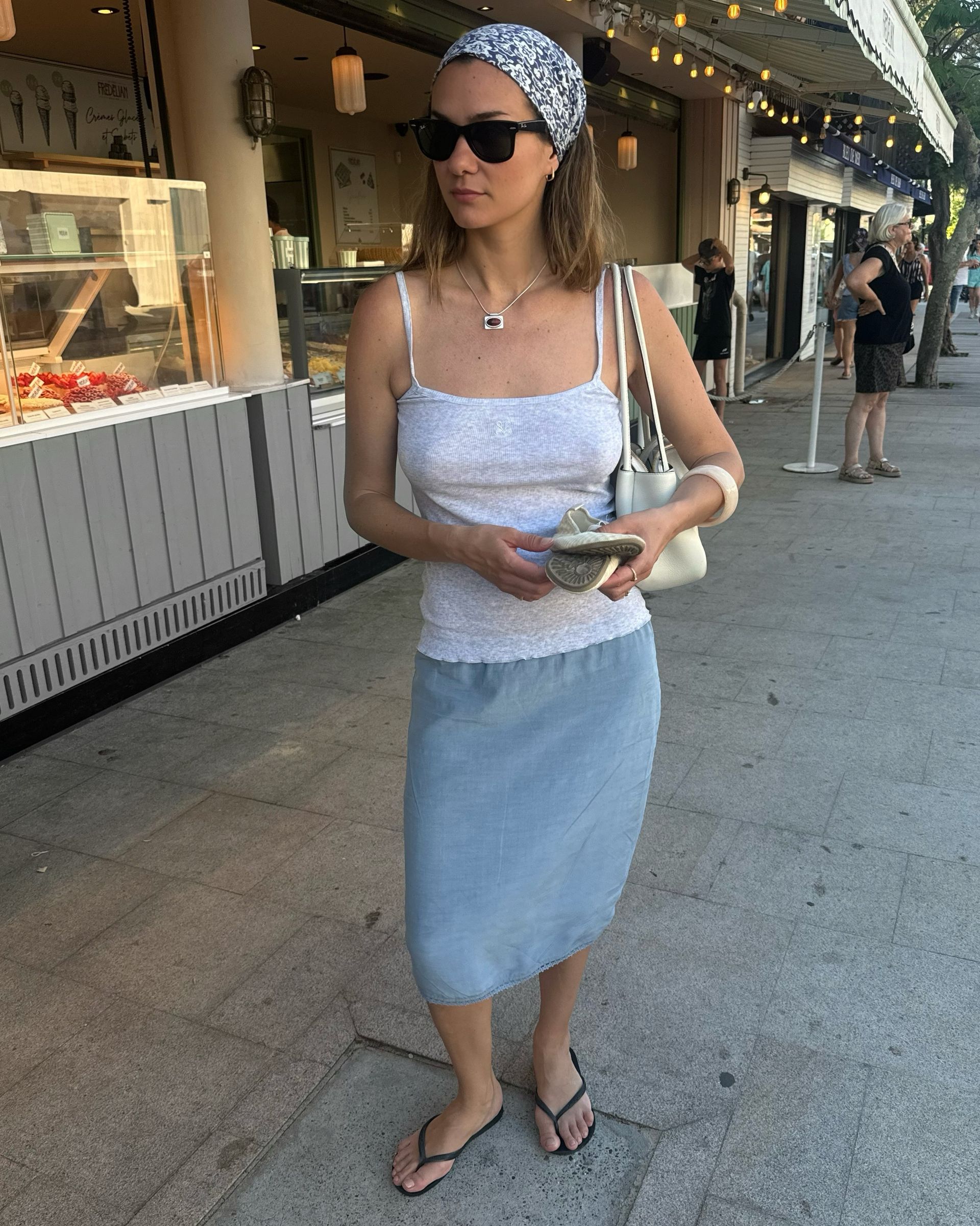 Woman holding a white handbag.