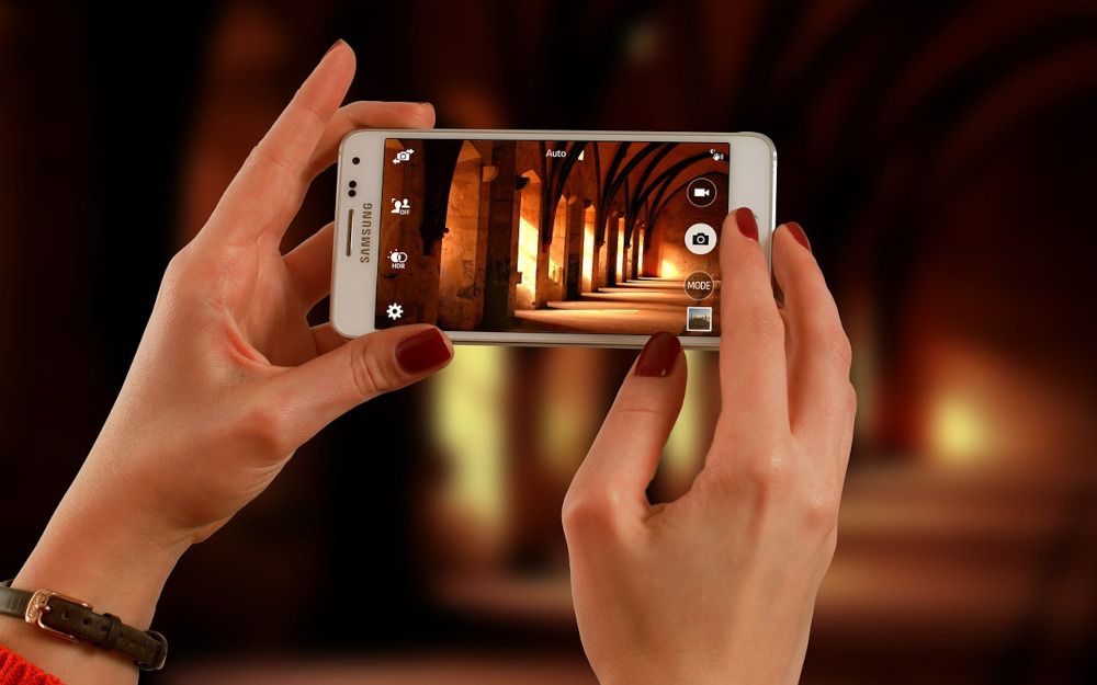 Women&#039;s hands holding smartphone in camera view