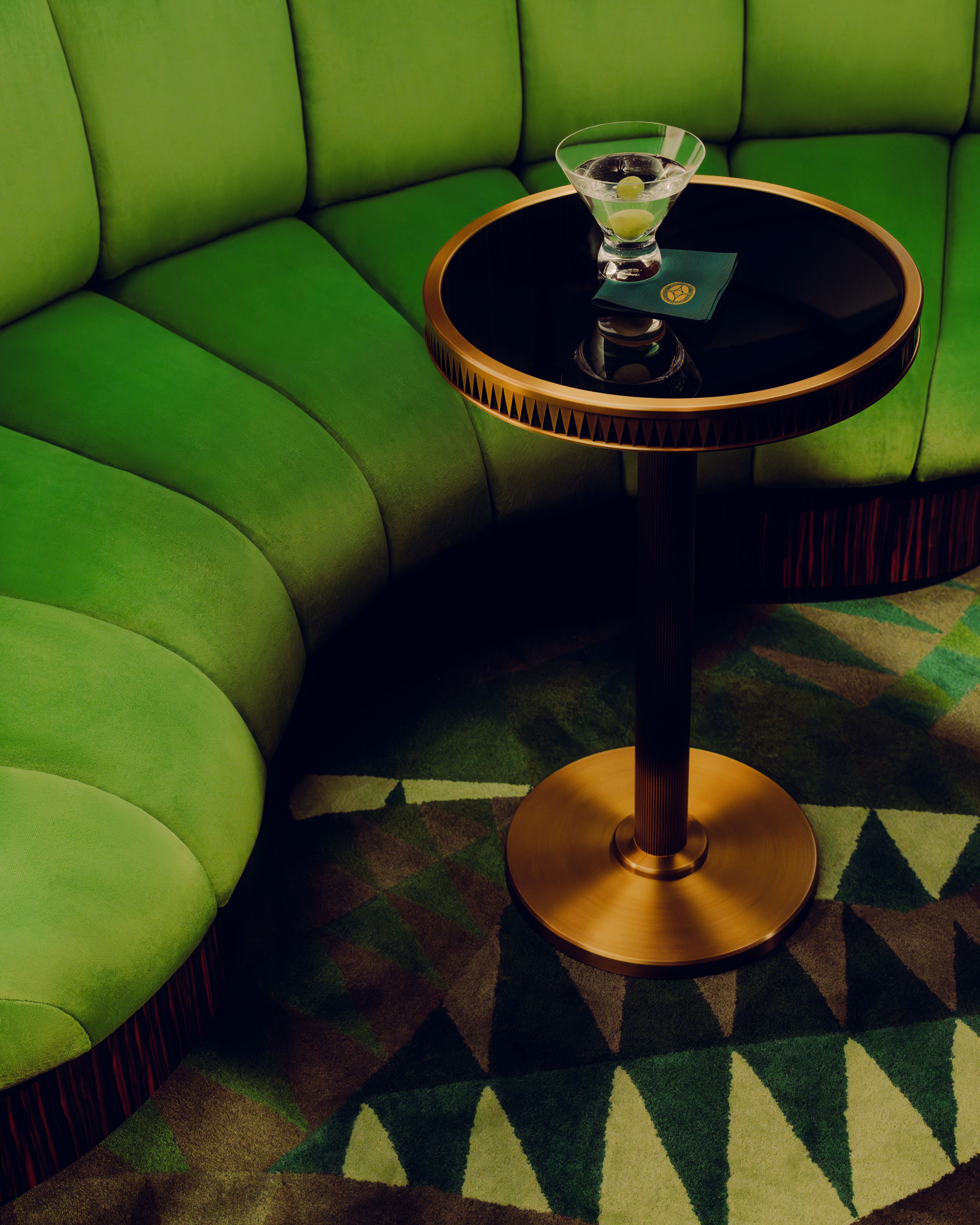 A series of images showcasing the vintage-inspired interiors of a luxury train, characterized by lacquered marquetry, plush textiles, geometrical patterns, and a chocolate, gold, cherry plum, green, and baby blue palette.