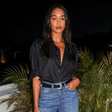 Laura Harrier styles a black shirt with blue jeans.