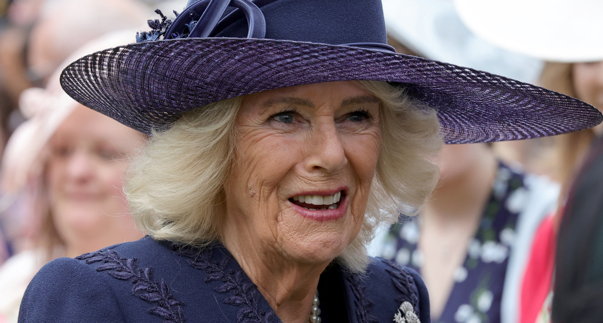 Queen Camilla wearing a blue hat and coat