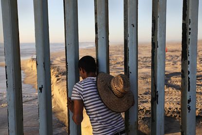A person looks from the Mexico side of the border at the U.S.