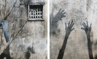 Hands reflect on a wall in the sun in Masima Nagar Village