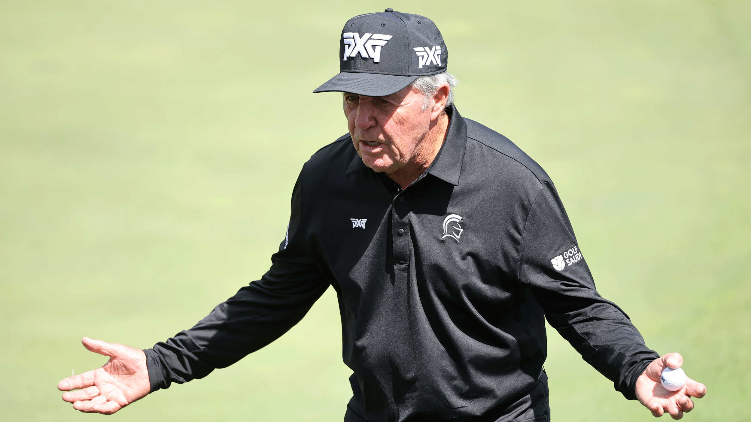 Gary Player stands with his hands outstretched during the 2026 Masters practice round