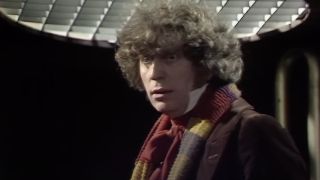 Tom Baker as The Fourth Doctor wearing scarf and brown coat
