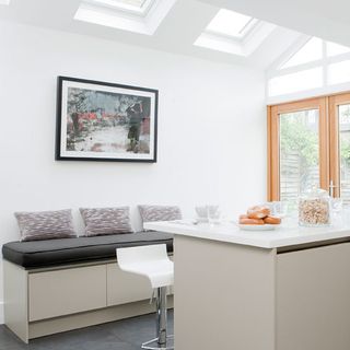 dining area with white wall and bench