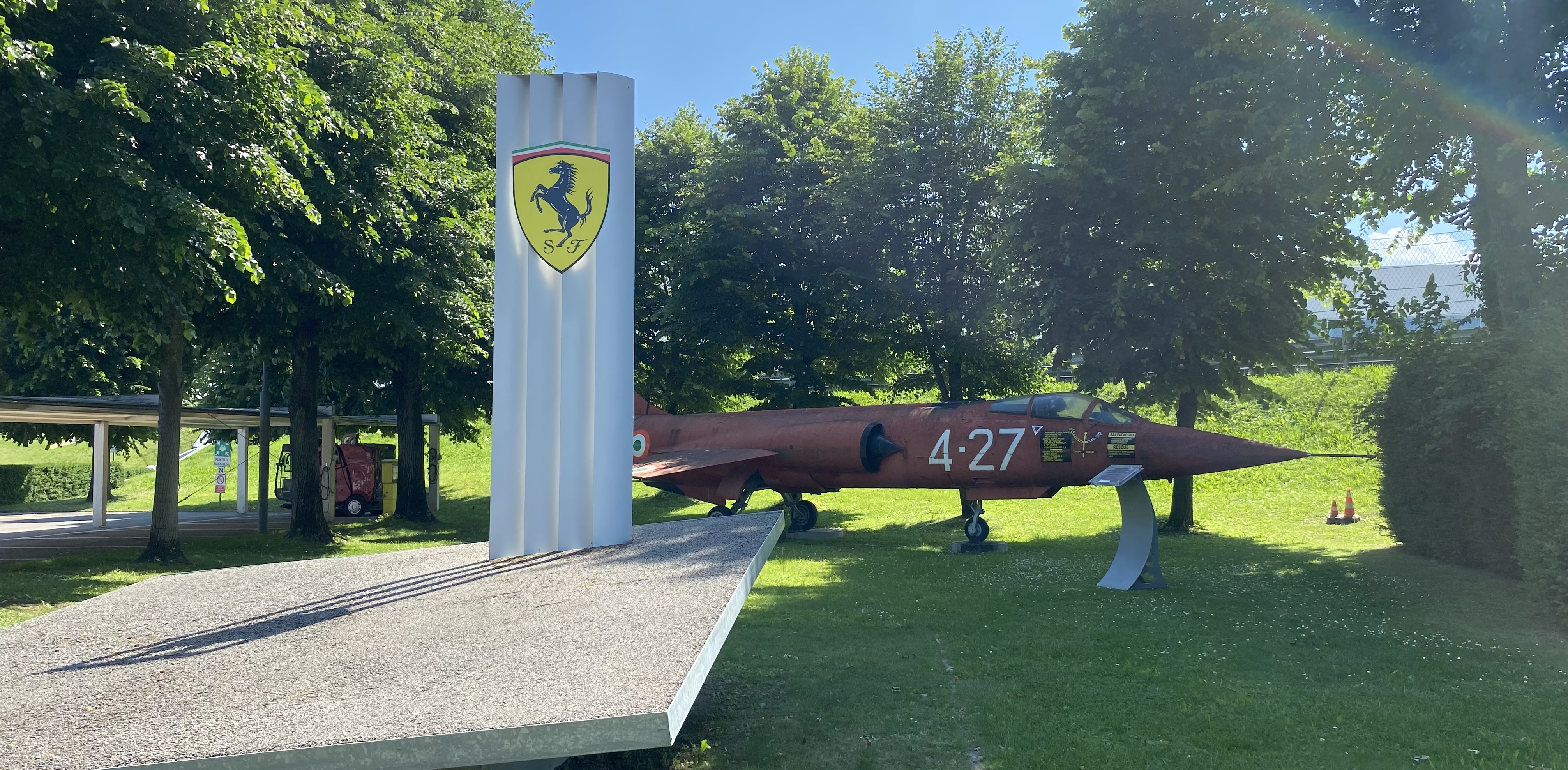 A photo of the F104 Starfighter behind the Ferrari logo located at Ferrari's Pista Di Fiorano race track.