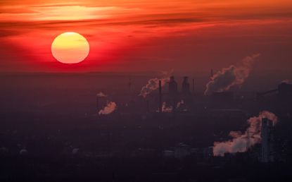 Steam and exhaust fill the evening sky.