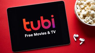 Tubi app on a tablet with popcorn and earbuds nearby