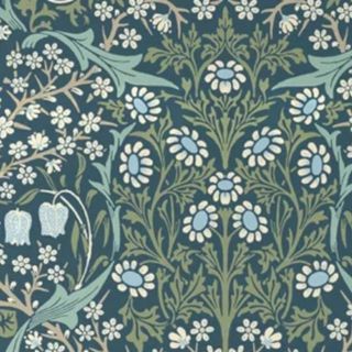 A square of dark green wallpaper with white and blue flowers adorning it and sage green leaves