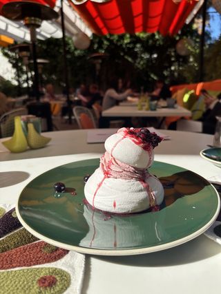 A pavlova sits on a green plate at Norma's at Parker Palm Springs