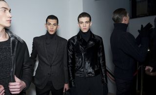 Male models stood next to each other with black outfits on