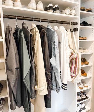 Closet interior with hanging rail featuring coats, surrounded by shoe storage