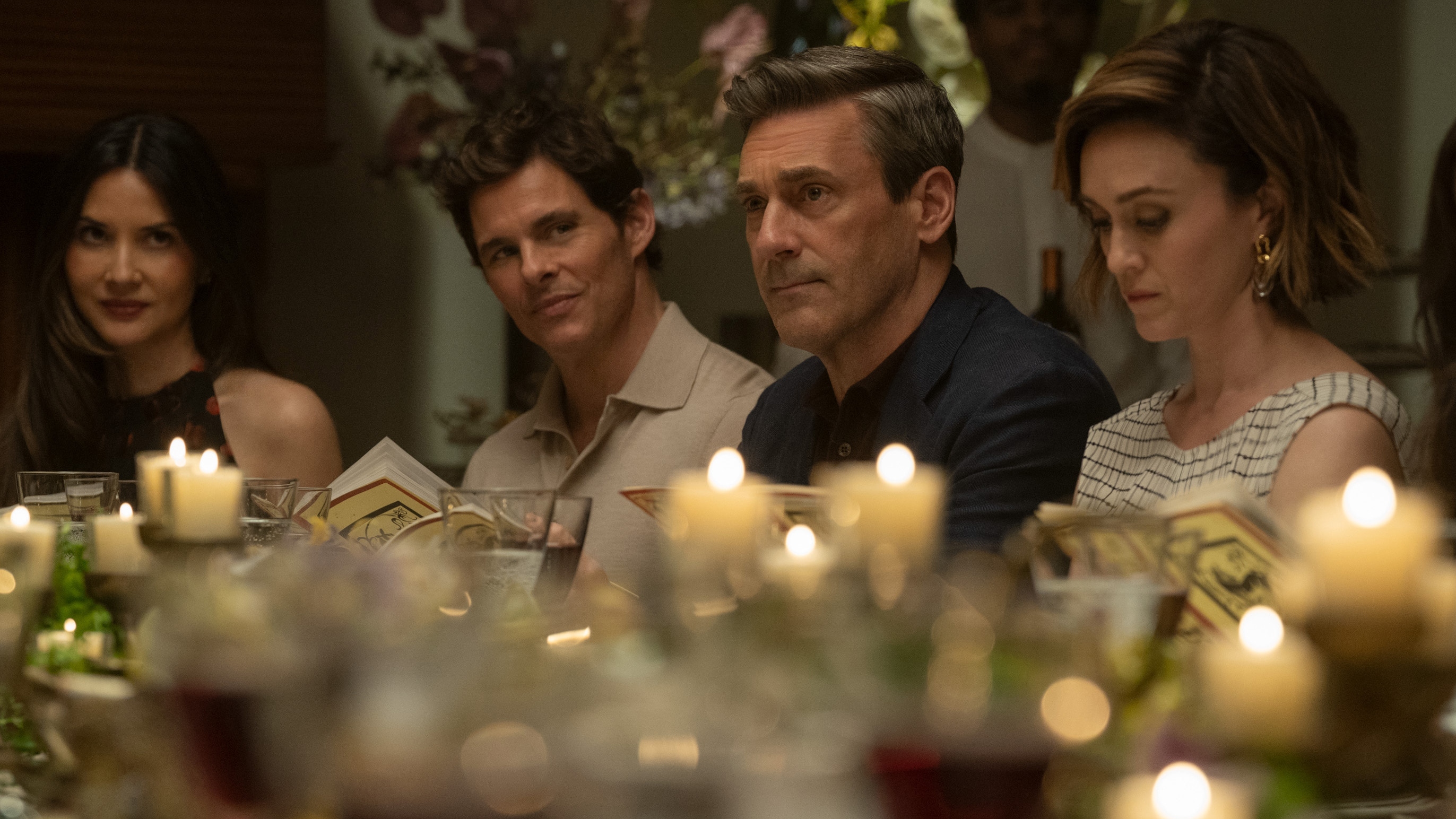 Olivia Munn, James Marsden, Jon Hamm and Heather Lind sitting at a table with candles in Your Friends and Neighbours season 2.