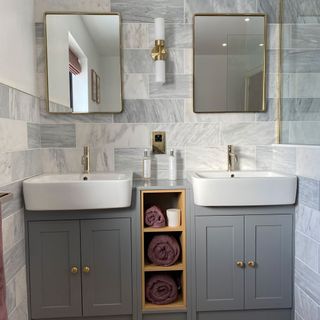 bathroom with grey tiles wall wash basin mirror and grey cabinets