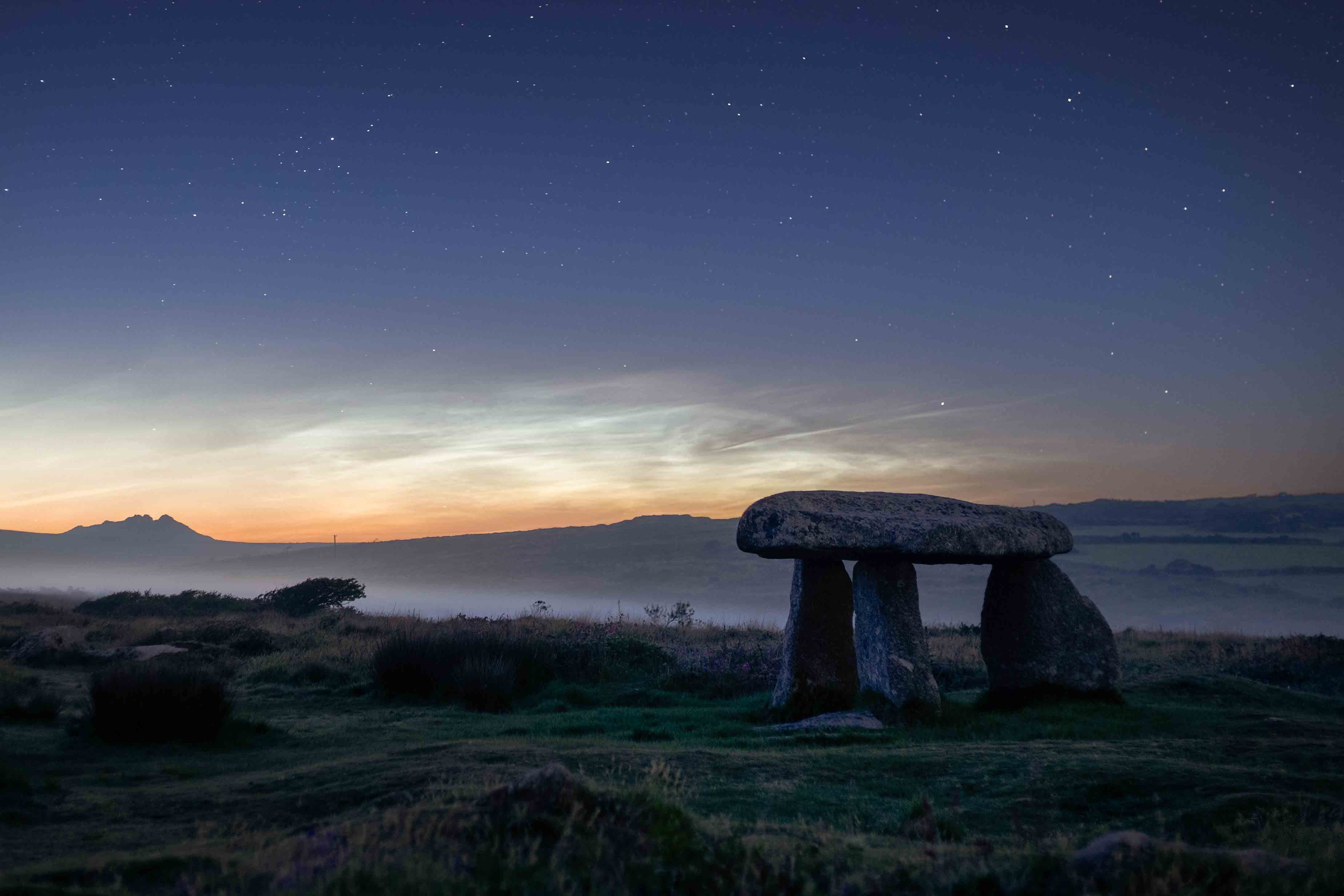 Pale night sky in background with rock formation in foreground