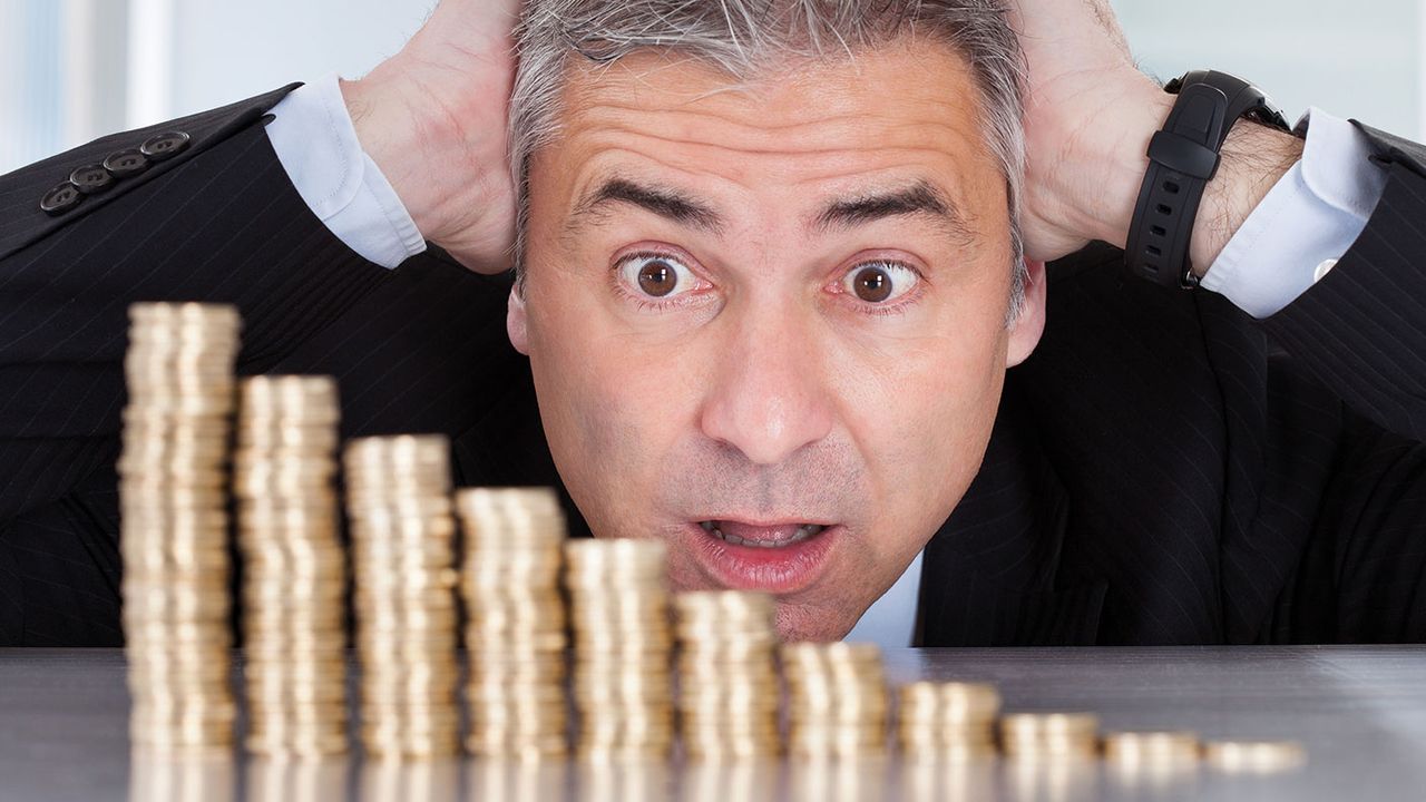 Man looking at a shrinking pile of coins