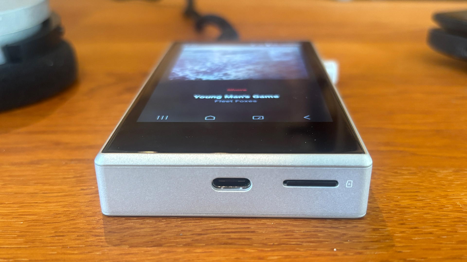 Astell &amp;amp; Kern PD5 portable music player on wooden table, viewed from end showing connections
