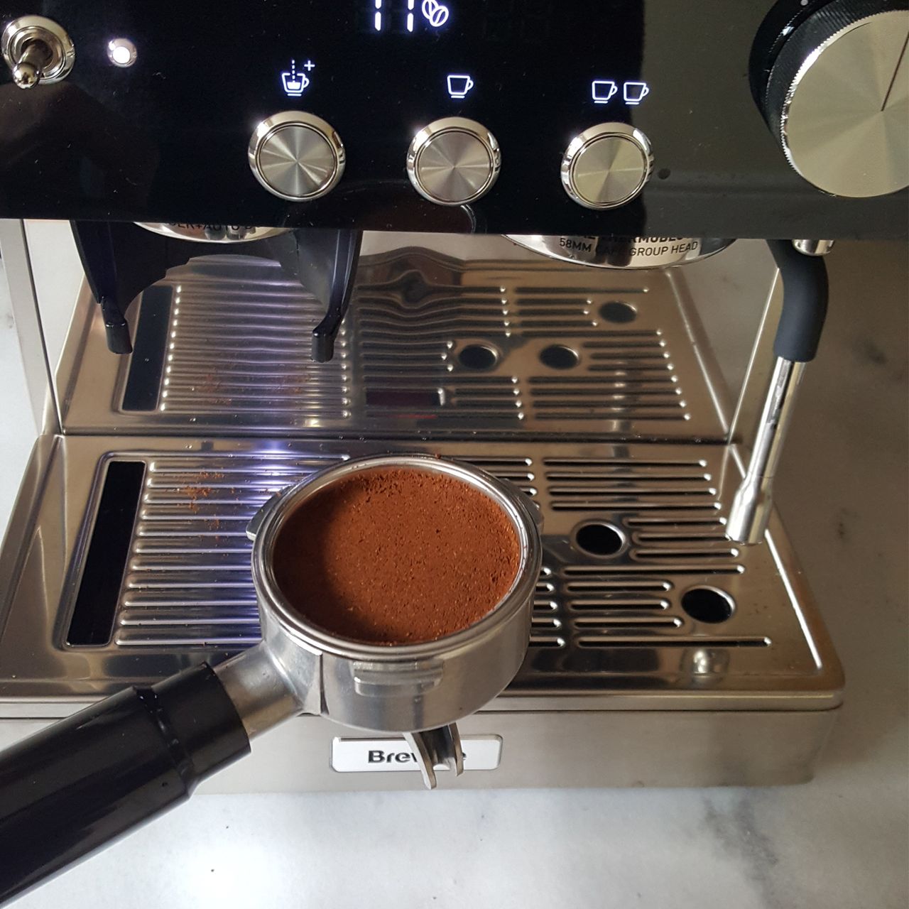 The Breville Barista Signature Espresso Machine being tested in a kitchen with a grey marble worktop