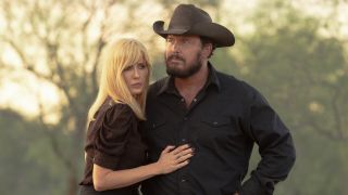 From left to right: Kelly Reilly holding Cole Hauser's torso. They're in character as Rip and Beth in Dutton Ranch. 