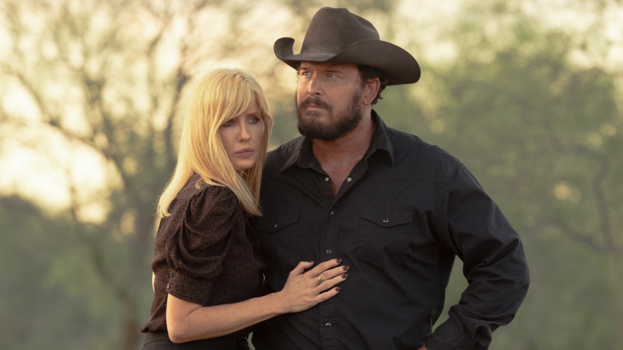 From left to right: Kelly Reilly holding Cole Hauser's torso. They're in character as Rip and Beth in Dutton Ranch. 