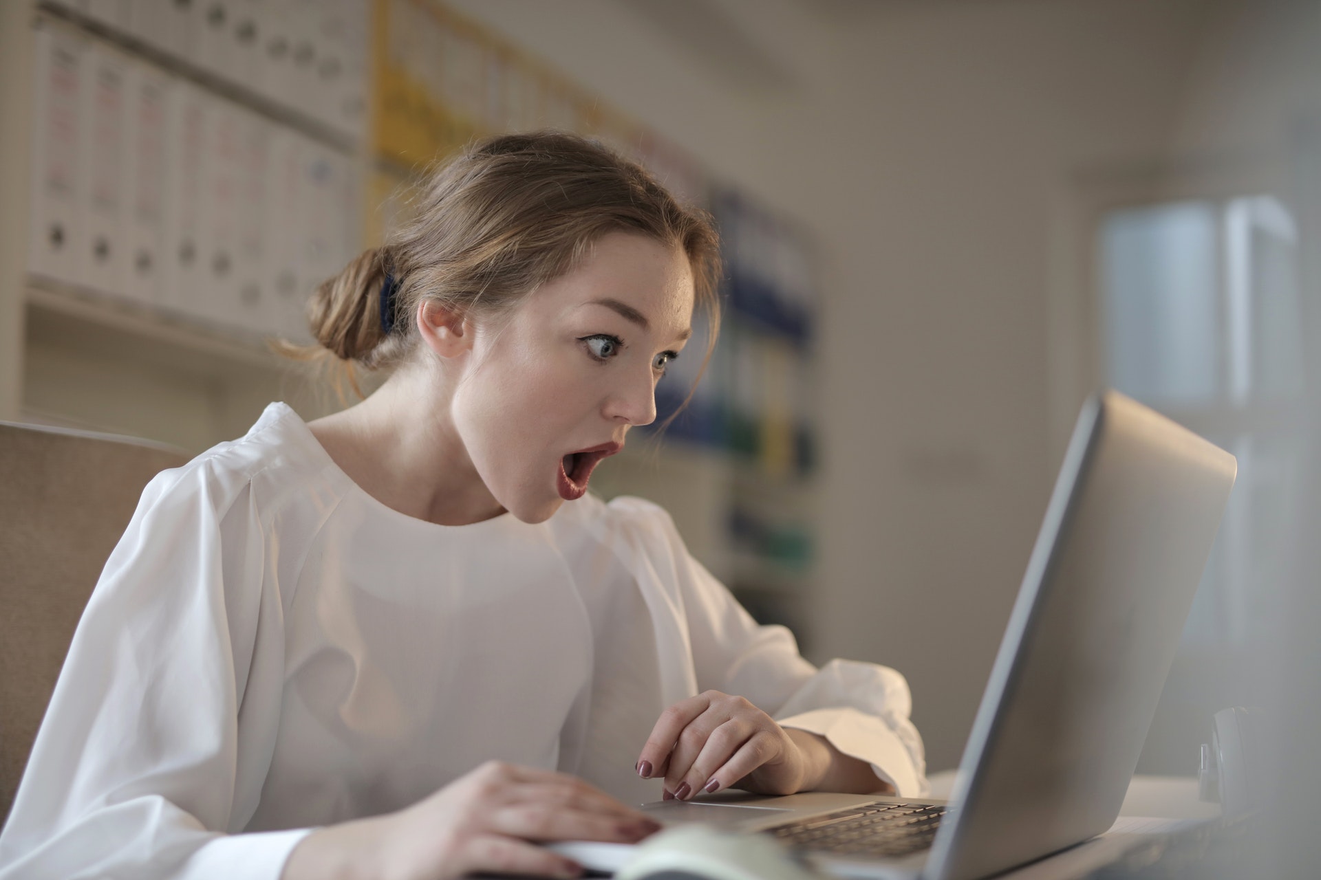 Woman looking at laptop in shock
