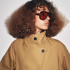 Zara model wearing short cropped trench coat and sunglasses.