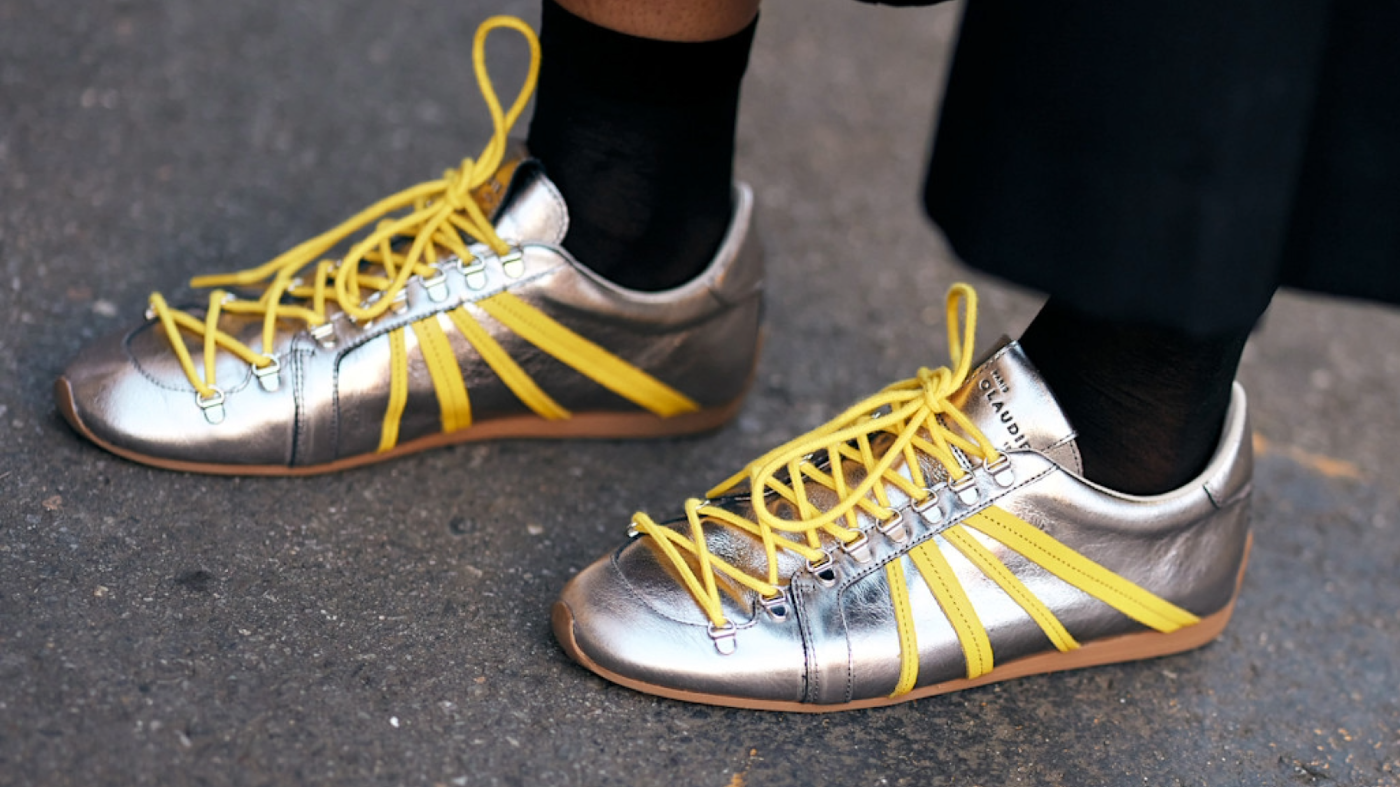 woman wearing silver sneakers with yellow laces. 
