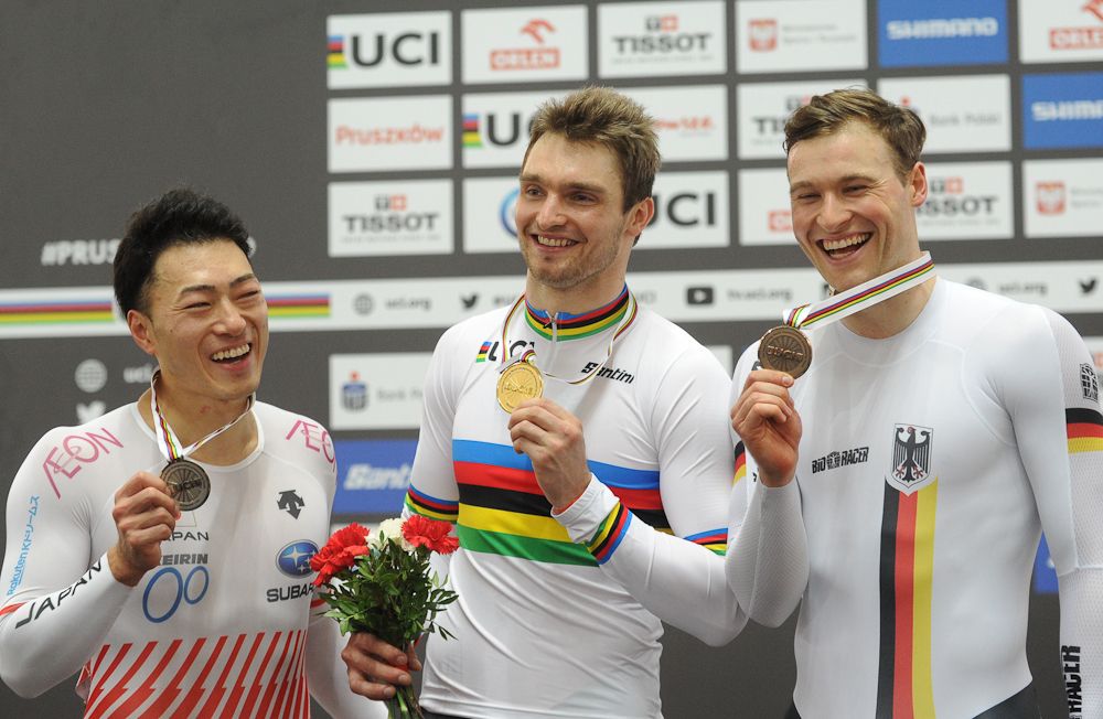 Silver medalist Japan's Yudai Nitta, gold medalist Matthijs Buchli from The Netherlands and Germany's Stefan Botticher celebrates on the podium after the Men's Keirin at the UCI Track Cycling World Championships