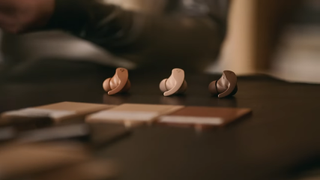 The neutral colored Beats Fir Pro earbuds on a table