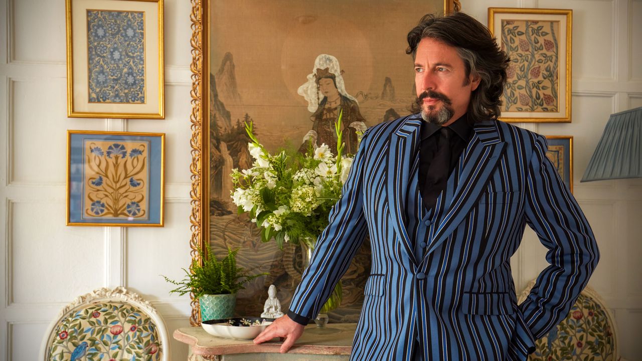 Laurence Llewelyn-Bowen standing beside a vase of flowers