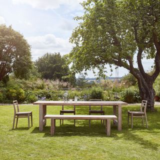 wooden garden table with bench and chair in garden
