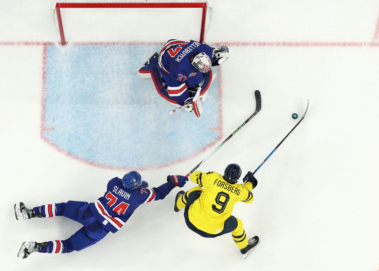 MILAN, ITALY - FEBRUARY 18: (EDITOR&amp;apos;S NOTE: Image was captured using a remote camera positioned above the field of play.) Jaccob Slavin #74 and Connor Hellebuyck #37 of Team United States defend the net against Filip Forsberg #9 of Team Sweden in the second period during the Men&amp;apos;s Quarterfinals Playoff match between the United States and Sweden on day 12 of the Milano Cortina 2026 Winter Olympic games at Milano Santagiulia Ice Hockey Arena on February 18, 2026 in Milan, Italy. (Photo by Jared C. Tilton/Getty Images)
