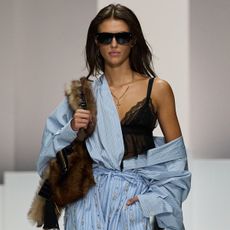 A women on dolce & gabbana runway wears a blue stripe shirt, black lace top, and blue stripe pants/