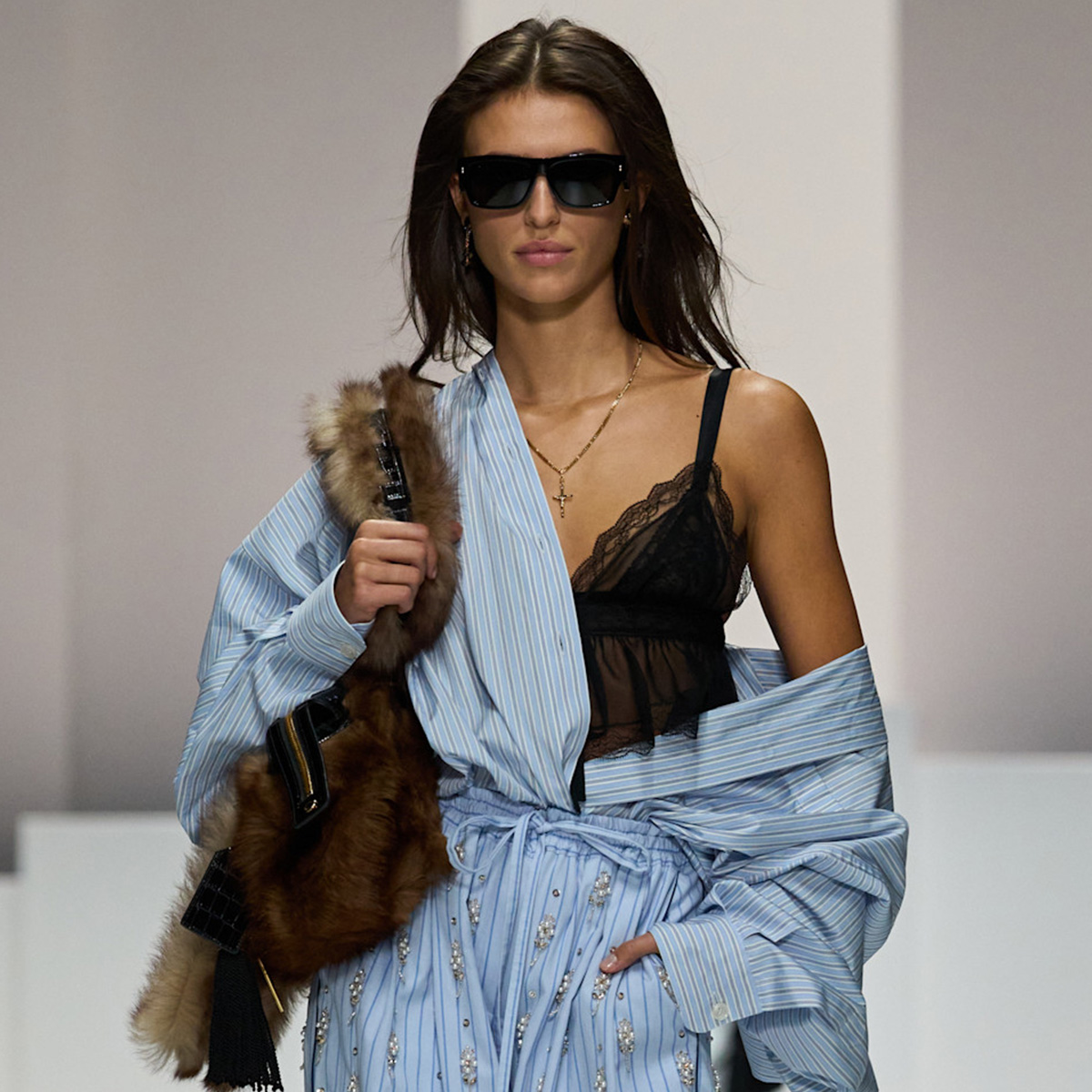A women on dolce 
gabbana runway wears a blue stripe shirt, black lace top, and blue stripe pants/