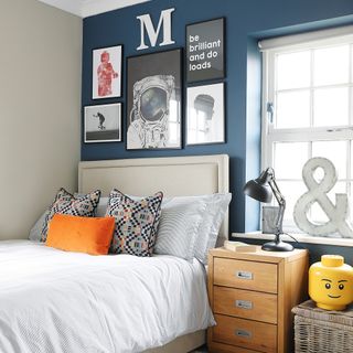 a young child's bedroom with a dark blue feature wall and Logo head storage