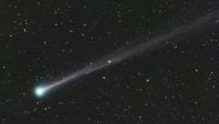 a comet with a long tail and a green blue head.