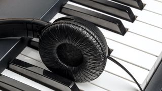 Single headphone earcup resting on the keys of a piano