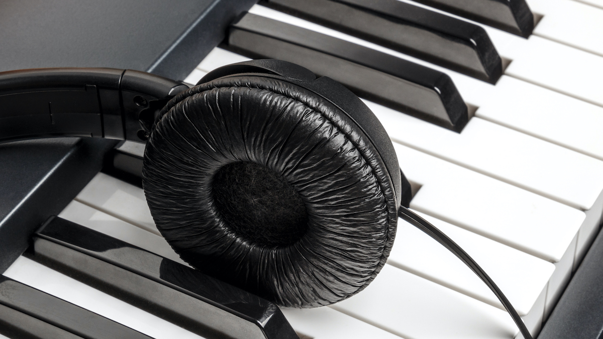 Single headphone earcup resting on piano keys