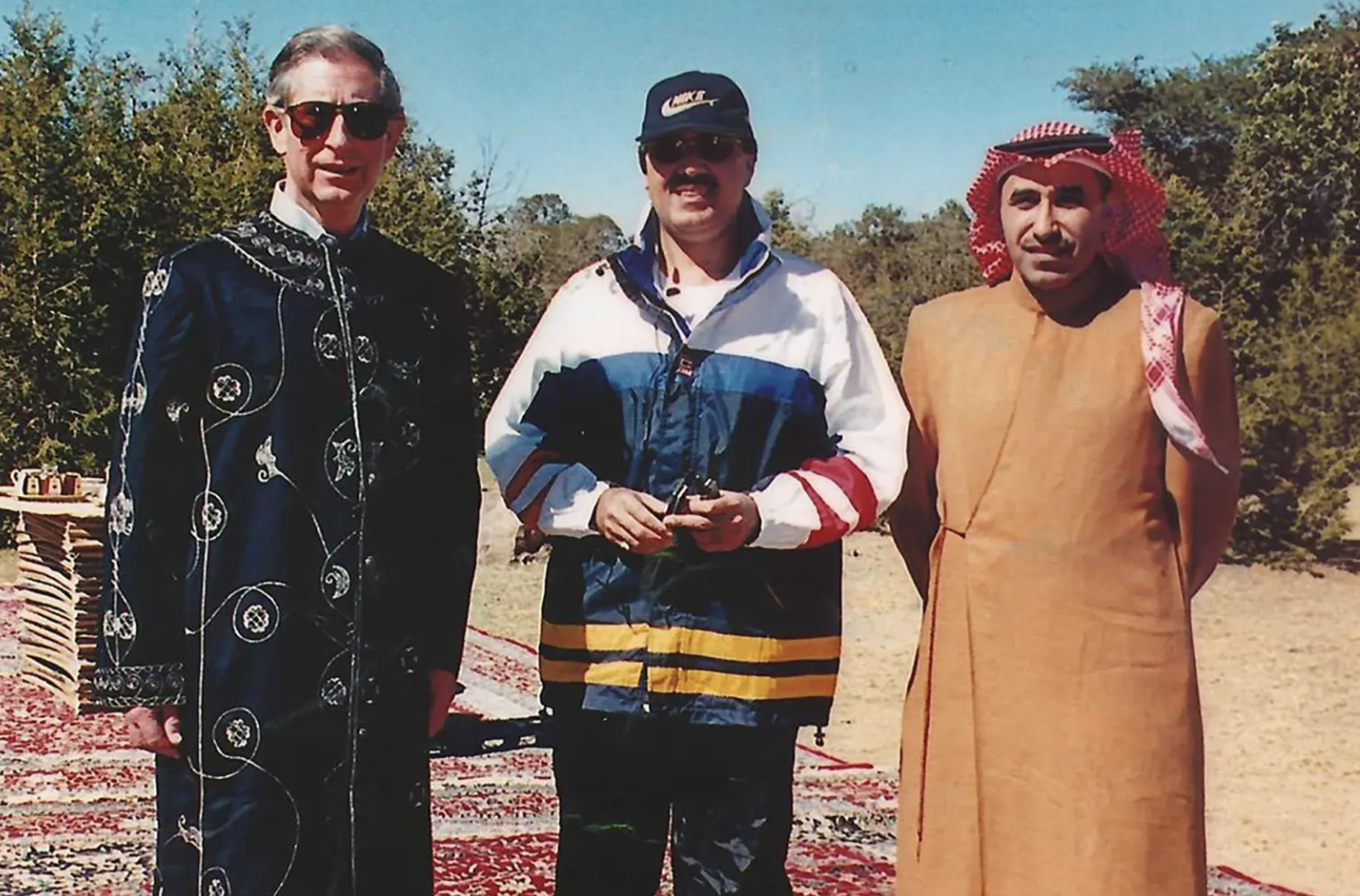 King Charles wearing a navy robe next to two Saudi men
