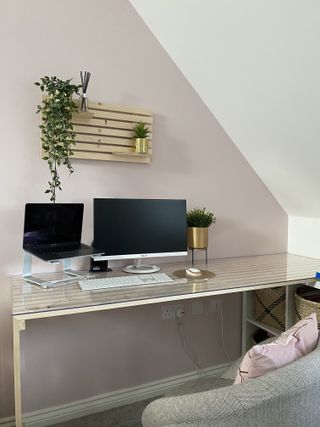 Finished slat desk DIY in corner with pink walls and house plants