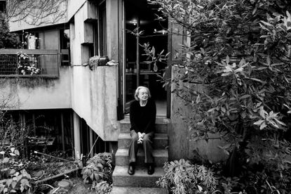 architect Ren&eacute;e Gailhoustet photographed sat at the steps of her work, a concrete structure in paris
