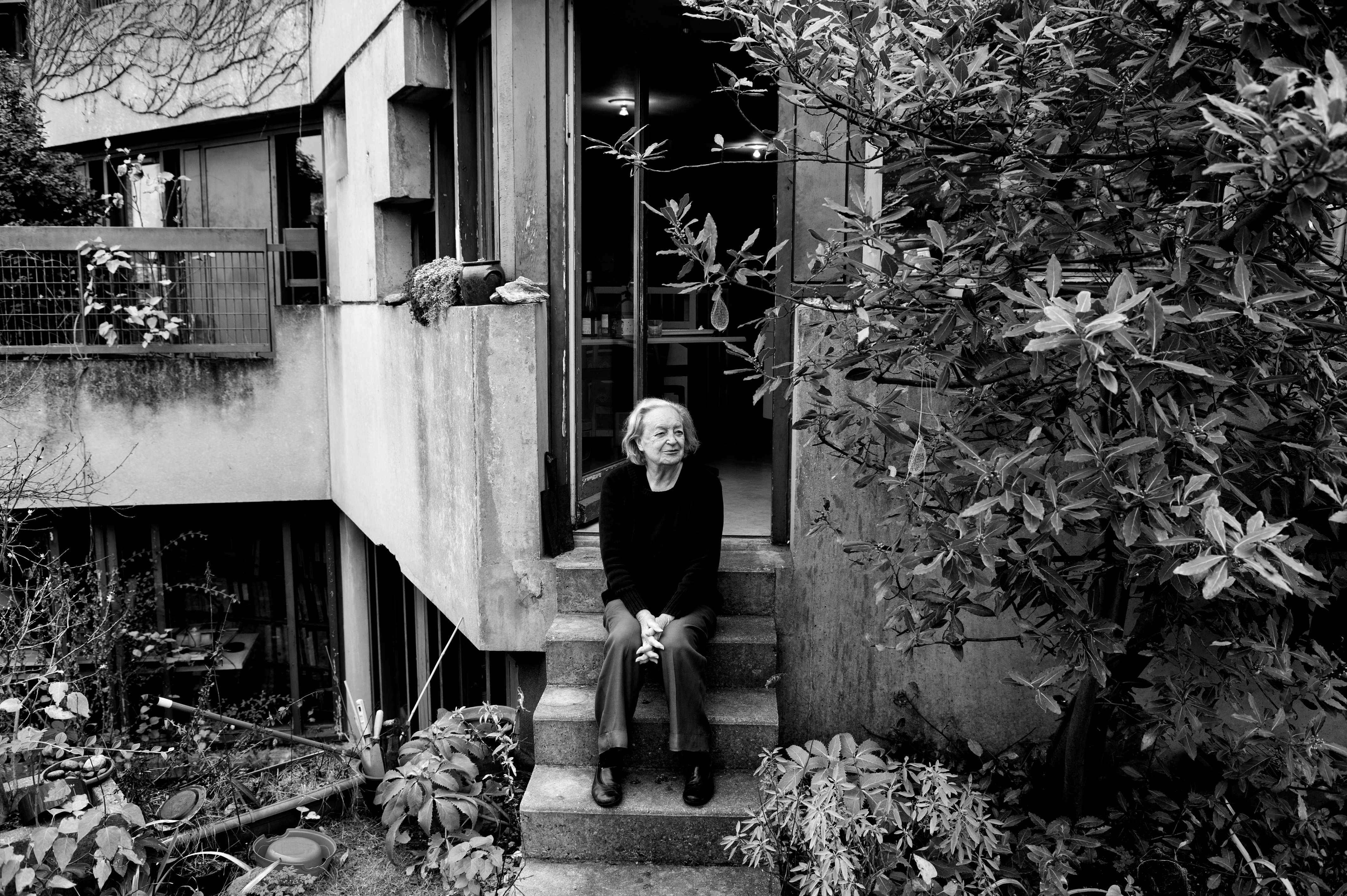 architect Ren&eacute;e Gailhoustet photographed sat at the steps of her work, a concrete structure in paris