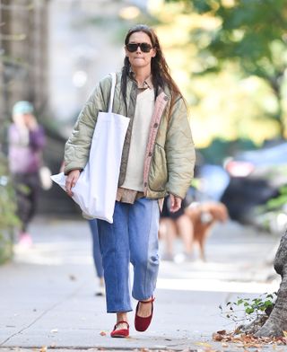 A photo of Katie Holmes wearing an olive green Marfa Stance cropped quilted jacket.