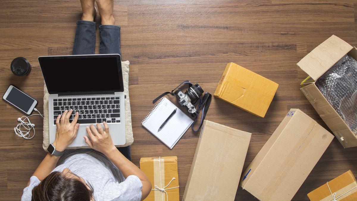 Top view of women working laptop computer from home on wooden floor with postal parcels