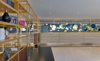 Le Méridien Etoile Hotel, Paris, France with blue and gold wall decorations and gold and wooden shelving holding books and accessories