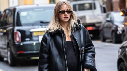 Suki Waterhouse wearing white chunky sneakers as part of her maternity style