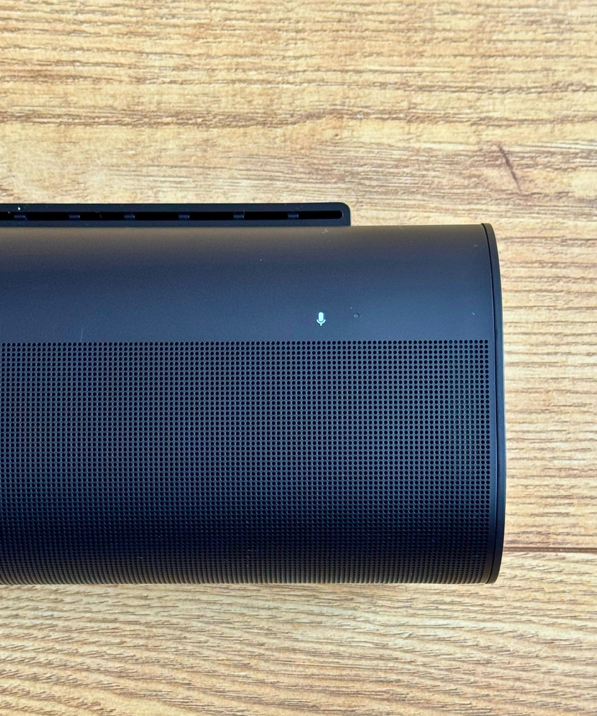 Closeup of the right-hand side of the Sonos Arc soundbar on wooden floor.